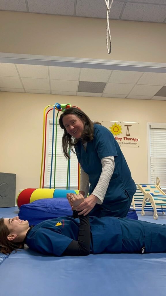 Dr. Kim Day and Dr. Cara Reynolds, occupational therapists, working on reflex integration patterns in Sunny Day Therapy sensory therapy gym in Lexington, Kentucky.